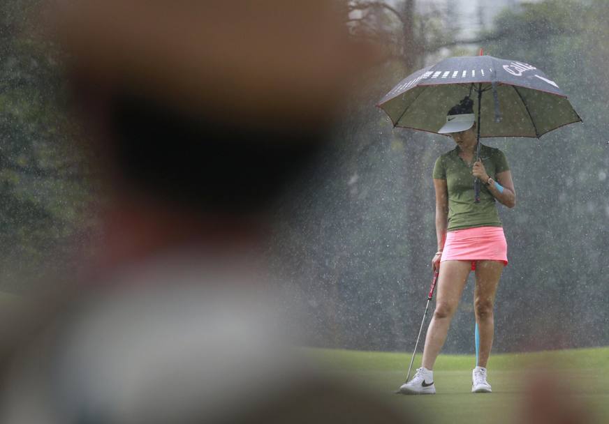 Golf. HSBC Women&#39;s Champions Golf . Michelle Wie sotto l&#39; ombrello. Singapore. (Epa)